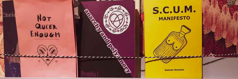 Three queer feminist zines on a shelf